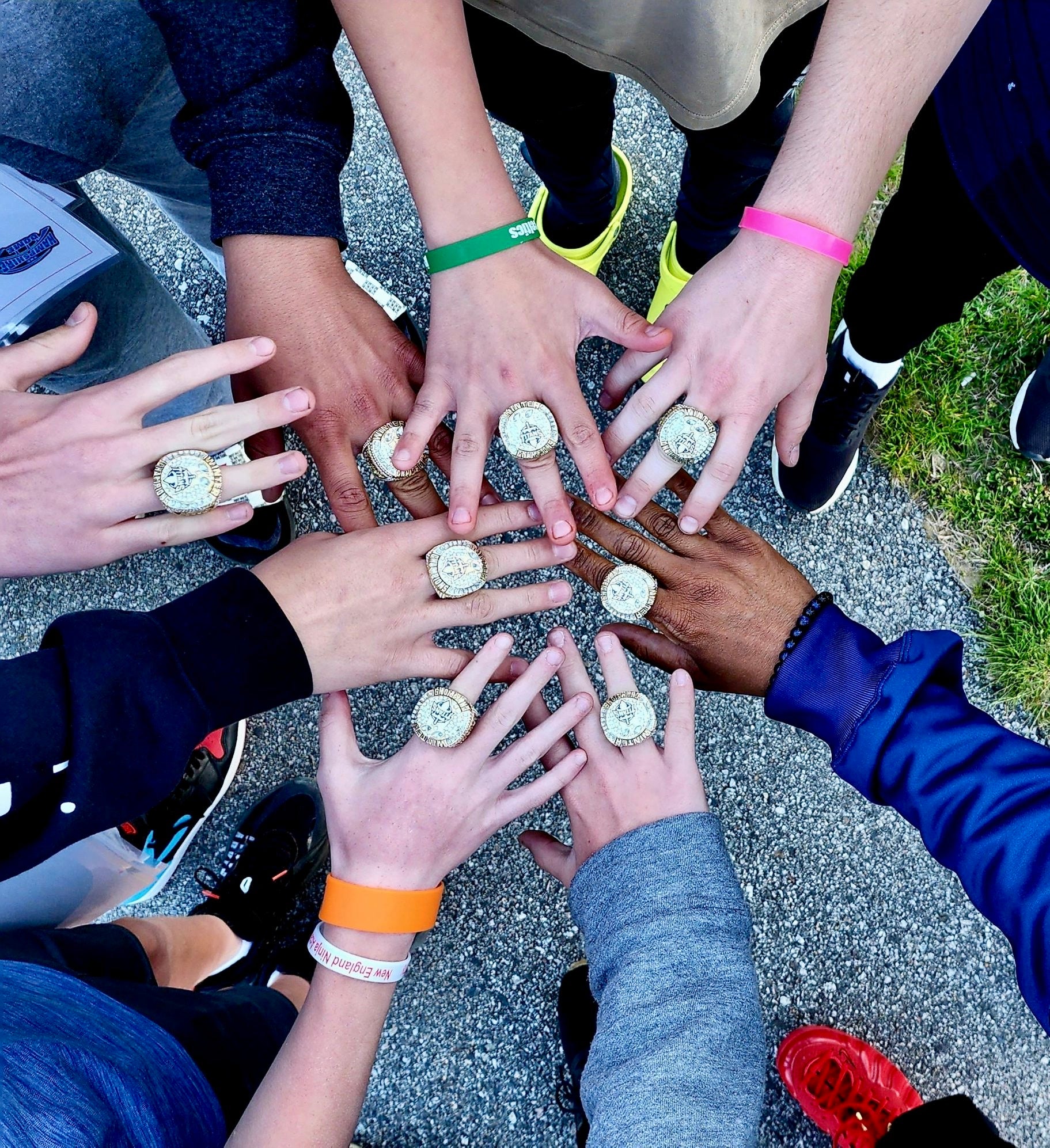 Youth athletes showing custom championship rings after a tournament