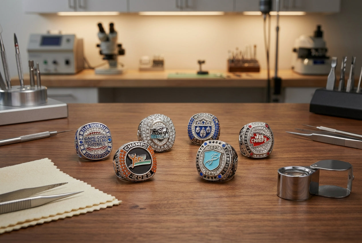 Five custom championship rings displayed on a workbench